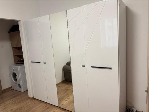 - Armario blanco con espejo en la habitación en EMC Apartament ultracentral, en Craiova