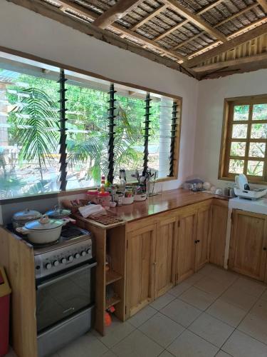 a kitchen with wooden cabinets and a stove and windows at MHARI Guest Rooms in San Juan