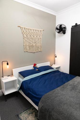 a bedroom with a bed with a blue comforter at The Pavilion End - Central Paddington Apartment in Sydney