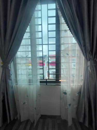 una ventana con cortinas en una habitación con vistas en MINH HUY HOUSE Mộc Châu, en Mộc Châu