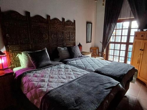 a bedroom with two beds and a large window at Wooden Creek Estate in Kempton Park