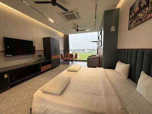 a hotel room with a bed and a flat screen tv at Hotel City Square in Dindigul