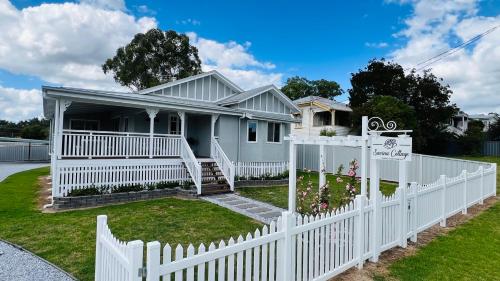 a white picket fence in front of a house at Savina Cottage in Stanthorpe