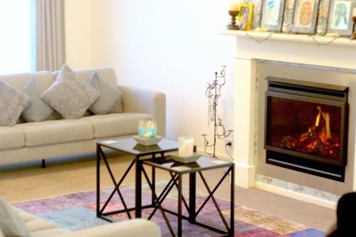 a living room with a couch and a fireplace at Beautiful Home Away From Home in Bowral in Bowral