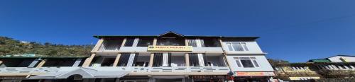 a large white building with a sign on it at Misty Mount By Himalayan Tree Hotels in Bhowāli