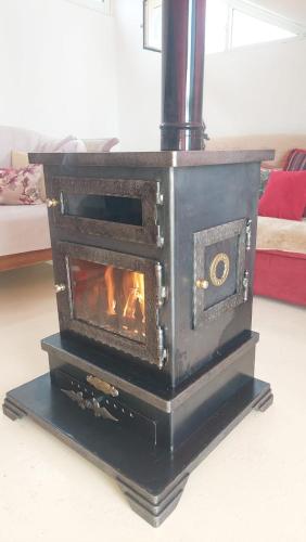 a black stove with a fire in a room at Arcadia Guesthouses - Ghazir, Lebanon in Ed Dkârîne