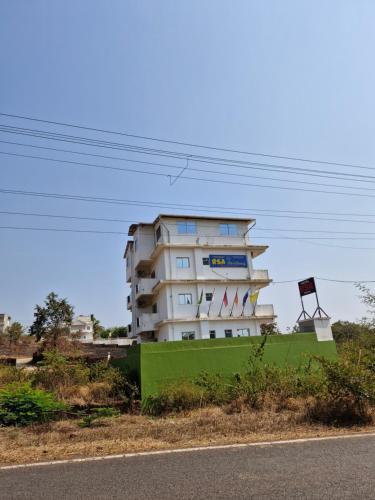 a building on the side of a road next to a street at Hotel RSA Residency in Pernem