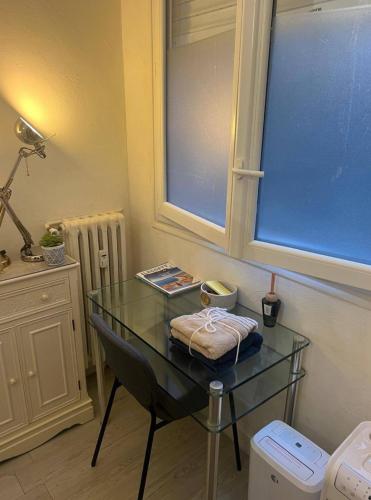 une table en verre dans une chambre avec fenêtre dans l'établissement Small apartment in Nice, à Nice