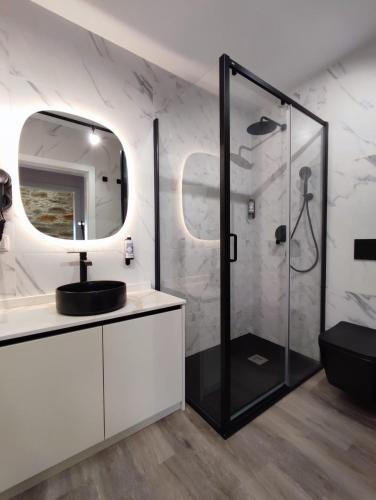 a bathroom with a shower with a sink and a mirror at Castas D'ouro Guest House in Casal de Loivos