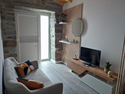 a living room with a couch and a television at Castas D'ouro Guest House in Casal de Loivos