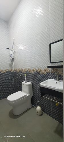a bathroom with a toilet and a sink at Homestay Cheq Gu 747 in Ayer Hitam