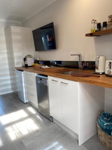 a kitchen with a counter with a sink and a dishwasher at Beautiful Bream Bay Studio - Ruakaka in Ruakaka