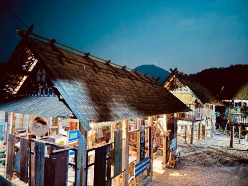 a group of wooden buildings with a roof at Ban Anoulak - Cultural Preservation Village in Nam Bak
