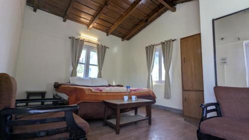 a bedroom with a bed and a table and a chair at Misty Mount By Himalayan Tree Hotels in Bhowāli