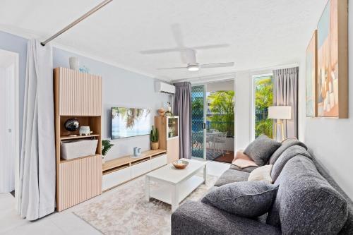 a living room with a couch and a table at Coastline Escape Renovated Unit - Great Location - Quiet Area - Parking Included in Gold Coast