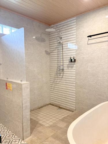 a bathroom with a shower and a bath tub at Adil Villa & Resort in Ubud