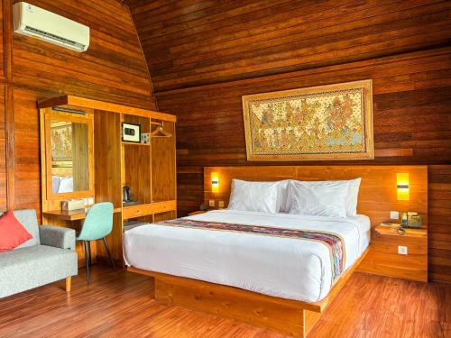 a bedroom with a large bed and a chair at Adil Villa & Resort in Ubud