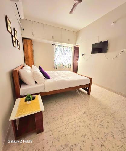 a bedroom with a bed and a couch and a table at Urban Suites in Coimbatore