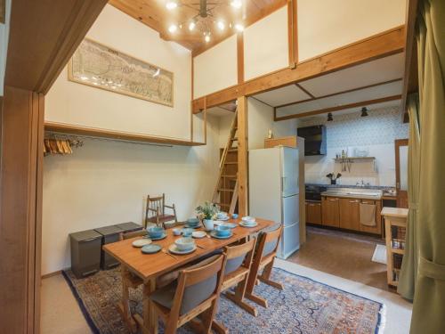 a kitchen and dining room with a wooden table and chairs at Cottage Snowhills Hakuba in Hakuba