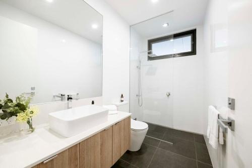 a white bathroom with a sink and a toilet at Anglesea Coastal Getaway - Prime Location in Anglesea