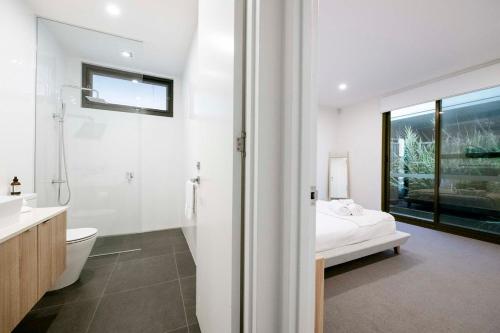 a white bathroom with a bed and a sink at Anglesea Coastal Getaway - Prime Location in Anglesea