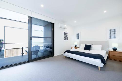 a bedroom with a bed and a large window at Anglesea Coastal Getaway - Prime Location in Anglesea