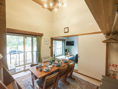 a dining room with a wooden table and chairs at Cottage Snowhills Hakuba in Hakuba