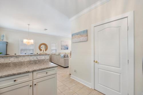 a kitchen with a white door and a living room at Captain's Chair 18A By Pkrm in Pensacola