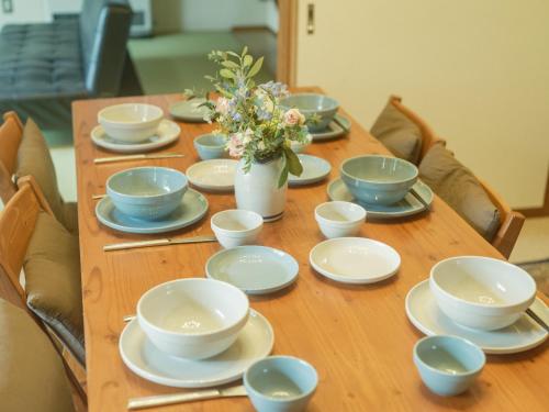 a wooden table with blue and white dishes on it at Cottage Snowhills Hakuba in Hakuba