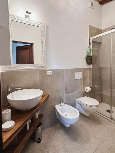 a bathroom with a sink and a toilet and a mirror at Antica Torre del Borgo in Certaldo