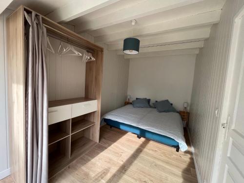 - une petite chambre avec un lit et un placard dans l'établissement La ptite maison de Royan pour 4 personnes avec jardin, à Royan