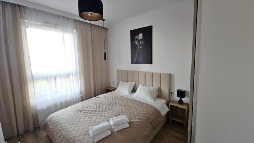 a bedroom with a bed with two towels on it at Nova Letnica Sea Apartaments in Gdańsk Letnica