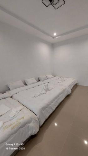 a large white bed in a white room at Buketree homestay satun in Ban Khok