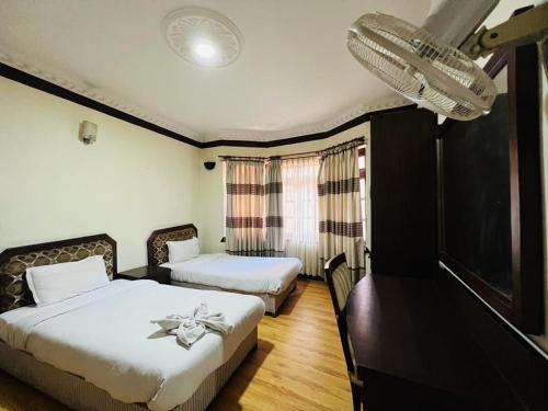 a hotel room with two beds and a mirror at Nest apartment in Kathmandu
