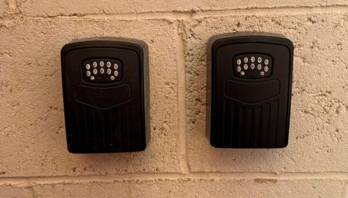two black objects on the side of a brick wall at PRIME LOCATION Luton home - FREE PARKING in Luton