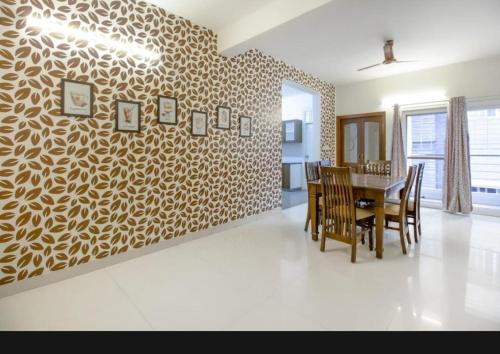a dining room with a table and a wall at SLN Suites, Near Baptist Hospital, Hebbala in Bengaluru