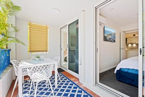 a bedroom with a balcony with a table and chairs at Coastline Escape Renovated Unit - Great Location - Quiet Area - Parking Included in Gold Coast