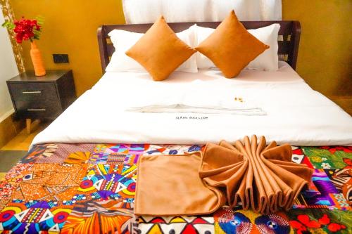 a bed with a blanket and pillows on it at Eliata Bush Camp in Kajiado