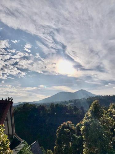 a view of the mountains with the sun in the sky at green slope villa glamping in Gitgit