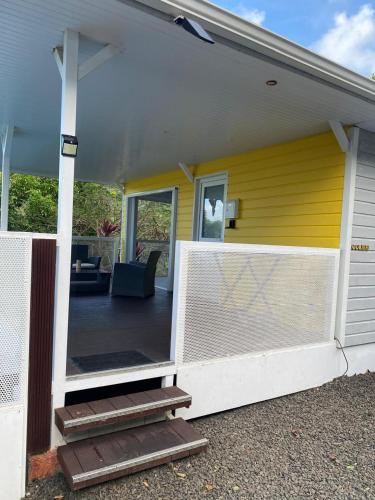 a front porch of a house with a yellow wall at Le domaine de Périolat in Le François