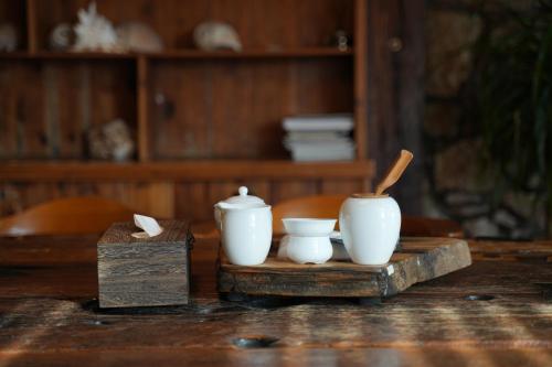 a table with three white vases on a wooden table at 温岭海山生活石屋民宿 in Shangma