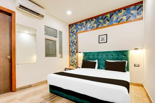 a bedroom with a large bed with a green headboard at Super Townhouse Hotel Silver Saffron in New Delhi
