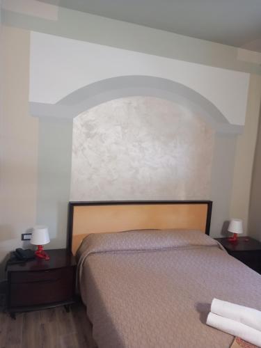 a bedroom with a bed and two tables with lamps at Hotel Le Calandre in Rubano