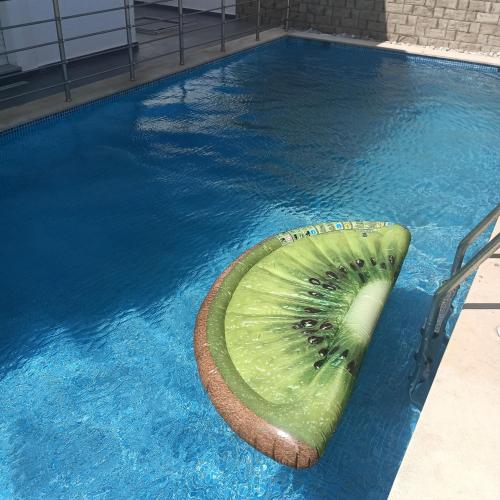 a slice of a kiwi floating in a swimming pool at Relaxing Villa with pool in El Haouaria