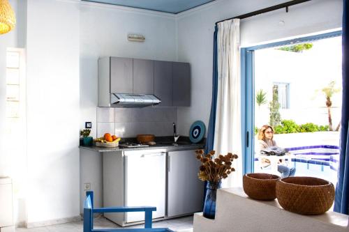 a kitchen with a woman looking out the window at Blue Calm in Daratso
