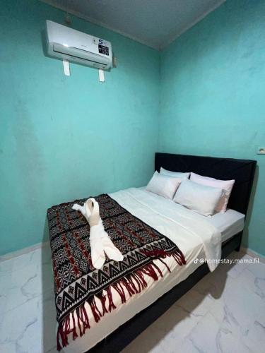 a bedroom with a bed with a stuffed animal on it at Novena Bungalow in Pulau Helihana