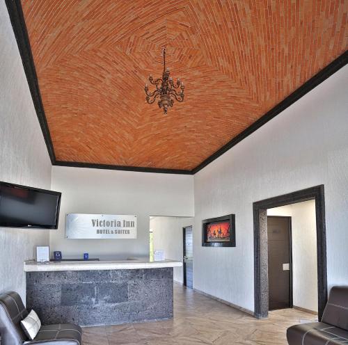 a living room with a ceiling with a chandelier at Hotel Victoria Inn in San Juan del Río