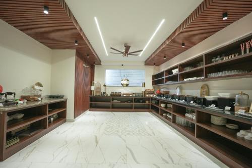 a large room with wooden shelves and a kitchen at Kaashvi Residency - Managed by Atithi House in Greater Noida