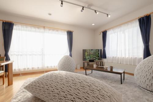 a living room with two chairs and a table at Rusutu,Ski&Family Lodge 66 in Kimobetsu