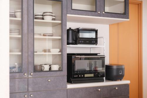 a kitchen with a microwave and a toaster oven at Rusutu,Ski&Family Lodge 66 in Kimobetsu